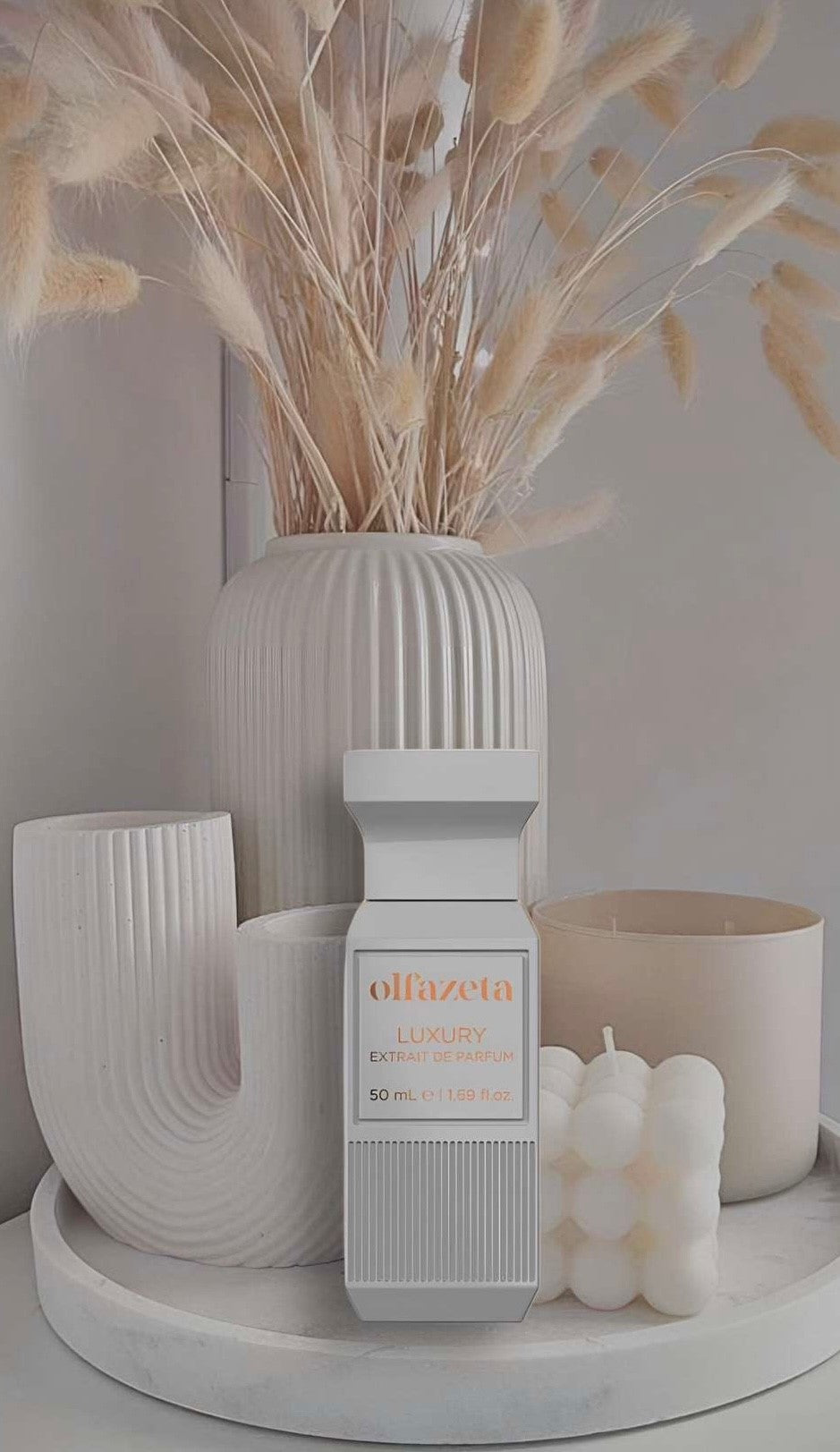 Unisex-Parfum in weißem Luxusflakon, stilvoll arrangiert vor minimalistischer Dekoration mit Kerzen und modernen Vasen in Beige- und Cremetönen