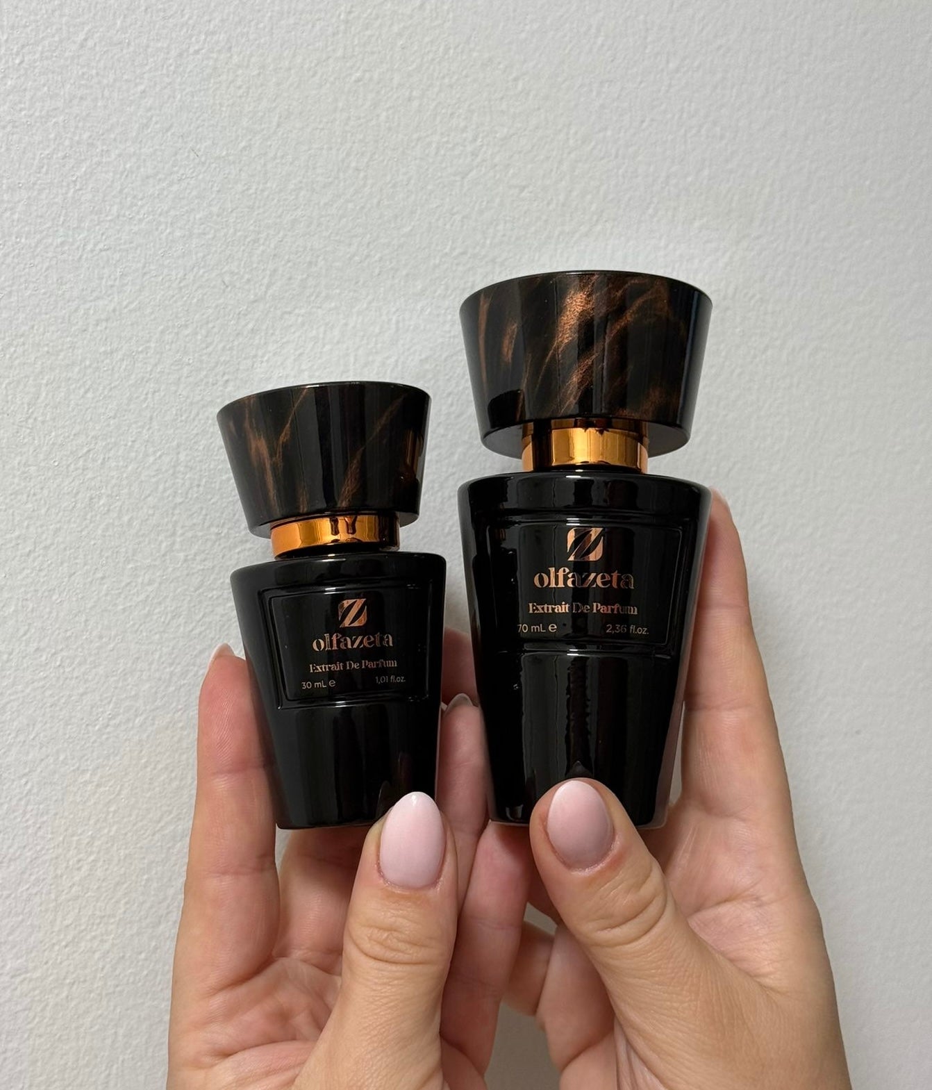 Zwei Größen des Olfazeta Extrait De Parfum in der Hand – 30 ml und 70 ml schwarze Flakons im Vergleich, ideal für unterwegs oder als Geschenk