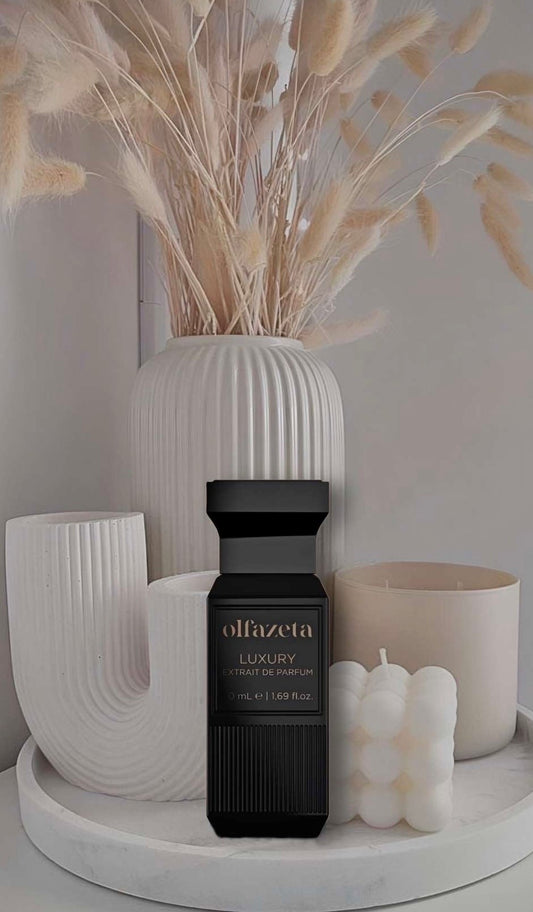 Unisex-Parfum von olfazeta in schwarzem Luxusflakon, stilvoll arrangiert vor minimalistischer Dekoration mit Kerzen und modernen Vasen in Beige- und Cremetönen