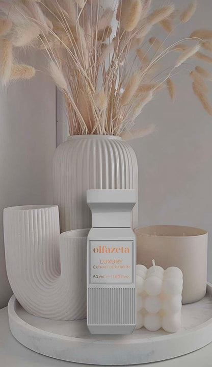 Unisex-Parfum in weißem Luxusflakon, stilvoll arrangiert vor minimalistischer Dekoration mit Kerzen und modernen Vasen in Beige- und Cremetönen